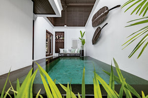 en suite swimming pool with tiled floor in a tropical hotel room setting